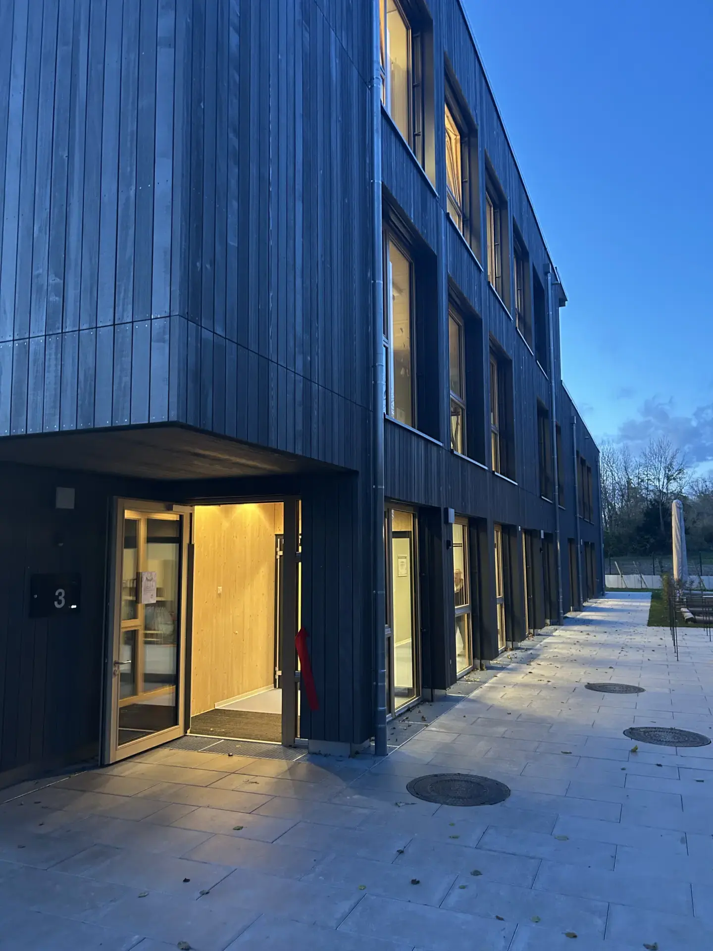 Eingangsbereich Kita Manzen – Neubau Kindertagesstätte in Holzelementbauweise mit dunkler Holzfassade, Hagedorn Ingenieure Göppingen