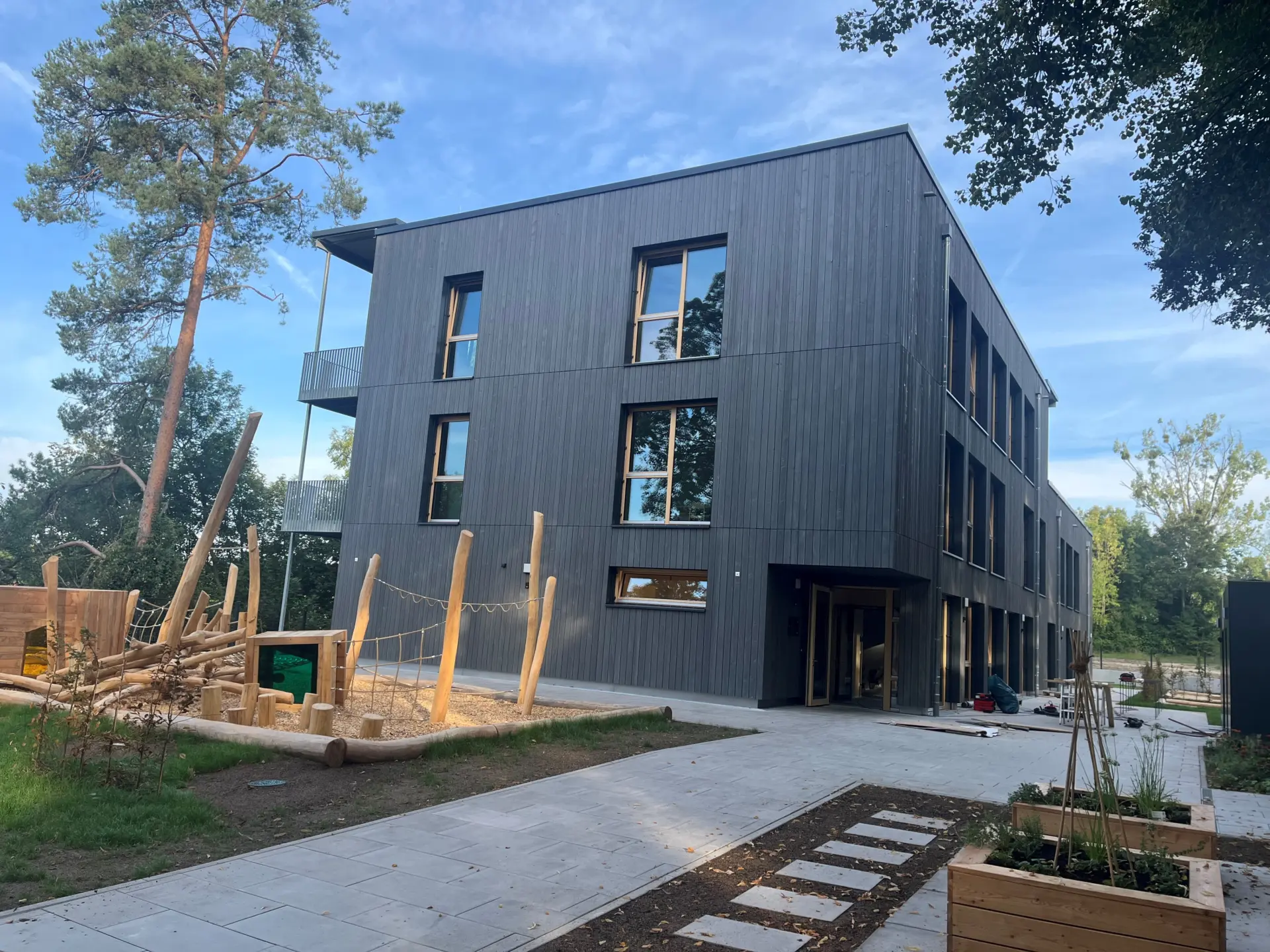 Neubau Kindertagesstätte Manzen in Holzbauweise – Außenansicht mit Spielplatz und Eingangsbereich, Tragwerksplanung Hagedorn Ingenieure Göppingen