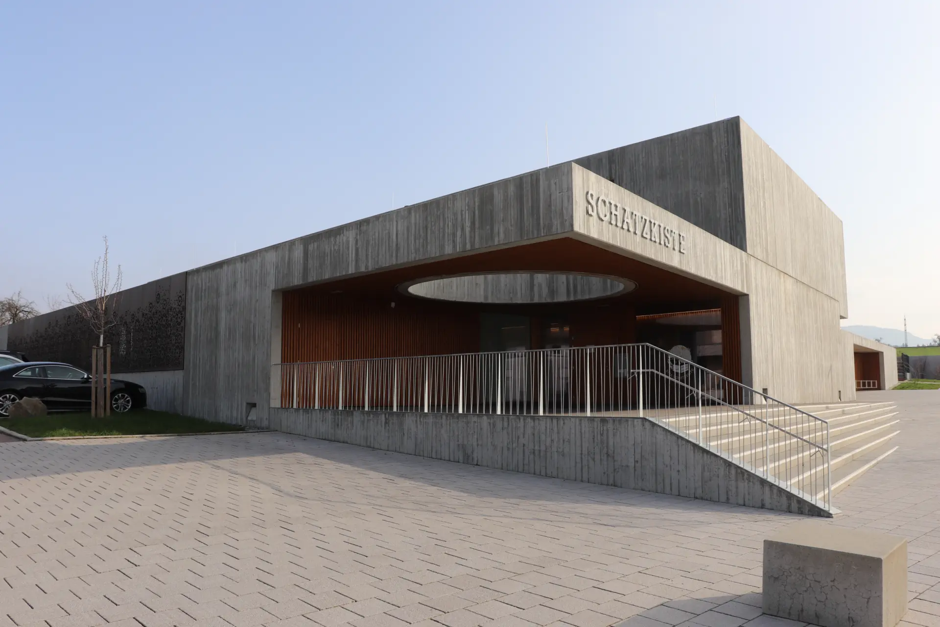 Neubau der Kita Schatzkiste mit Sichtbeton-Tragwerk, Holzverkleidung und ovaler Dachöffnung