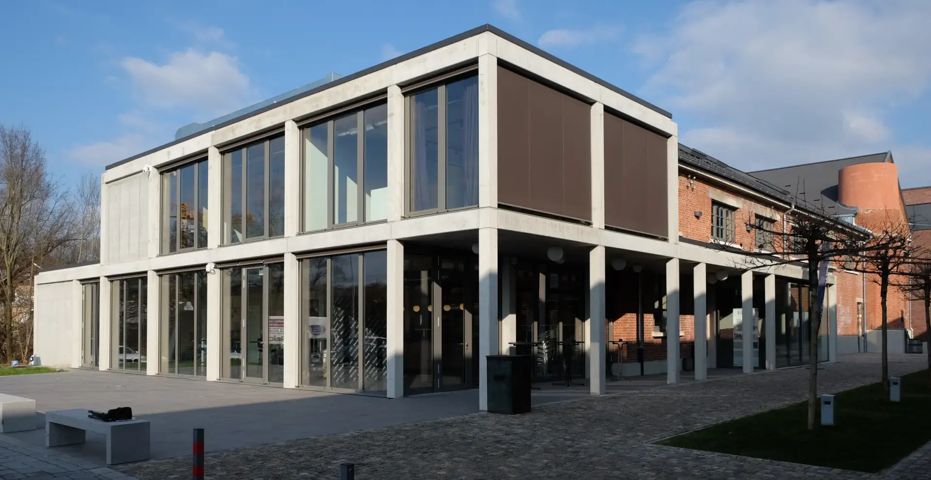 Zweigeschossiger Neubau mit Sichtbeton-Tragwerk und großflächiger Glasfassade